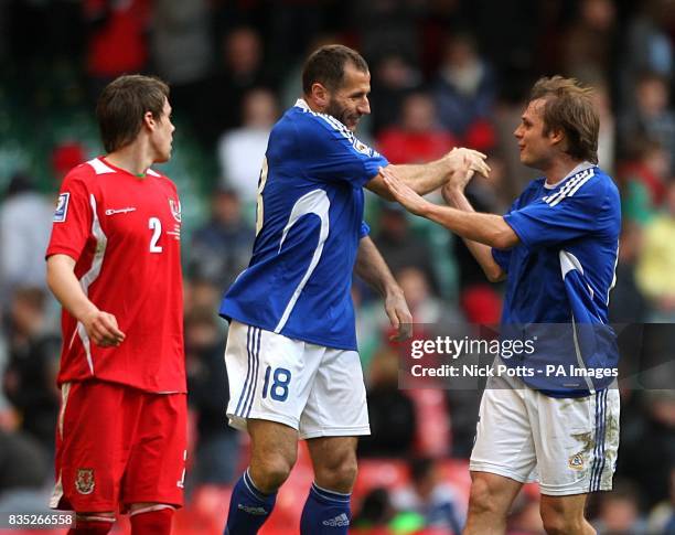 Wales' Chris Gunter stands dejected as Finland's Shefki Kuqi celebrates scoring his sides second goal of the game with teammate Markus Heikkinen