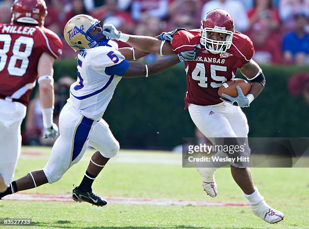 Williams of the Arkansas Razorbacks stiff arms DeAundre Brown of the Tulsa Golden Hurricanes at Donald W. Reynolds Stadium on November 1, 2008 in...