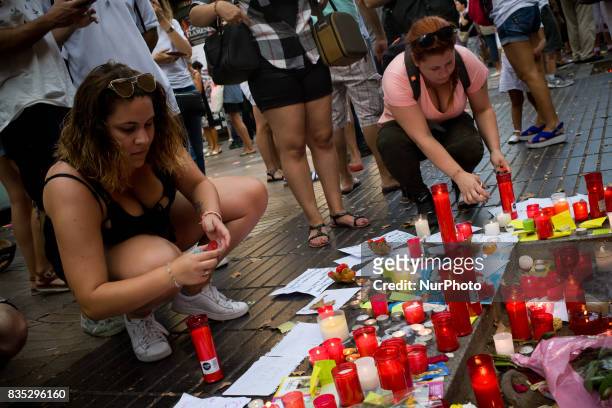 Two women light candles in Las Ramblas of Barcelona, Spain, on 18 August 2017, to pay tribute to the victims a day after a van ploughed into the...