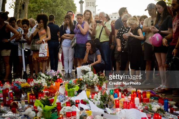People stands next to candles and flowers in Las Ramblas of Barcelona, Spain, on 18 August 2017, to pay tribute to the victims a day after a van...