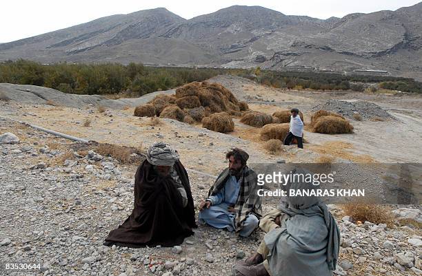 By Hasan Mansoor : Pakistani earthquake survivors sit next to a green apple farm in Wam on November 2, 2008. The sweeping valley of Ziarat district...