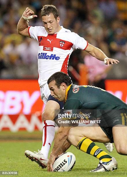 Australian player Glenn Stewart scores as England defender Danny McGuire attempts to stop him in their Rugby League World Cup match at the Docklands...