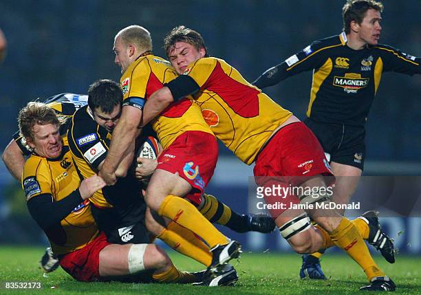 Damien Varley of Wasps is tackled by Jamie Ringer, Richard Fussell and Ashley Smith of Newport Gwent Dragons during the EDF Energy Cup, Group A match...