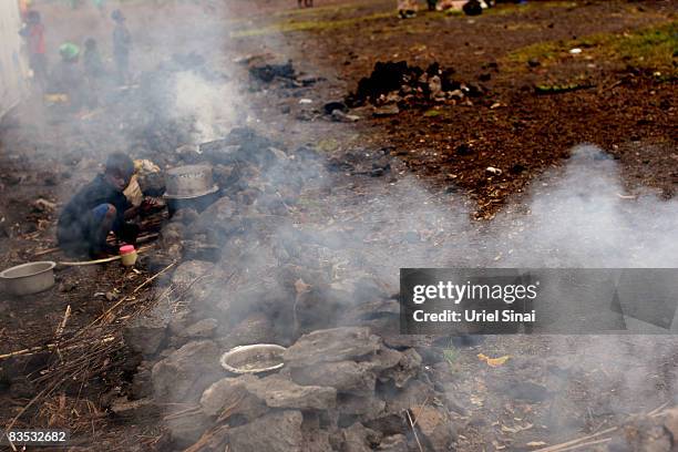 Congolese boy cooks in an Internally Displaced People camp in Kibati towards Kibumba and Rugari on November 2, 2008 just North of Goma, in the...