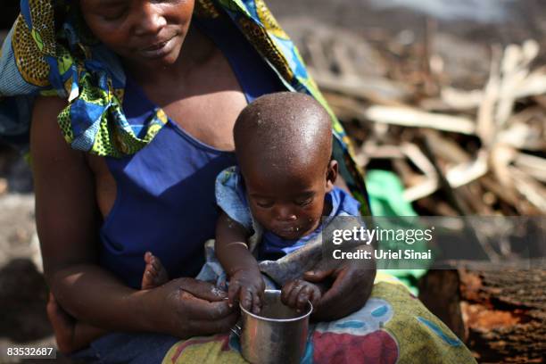 Congolese woman feeds her baby in an Internally Displaced People camp in Kibati towards Kibumba and Rugari on November 2, 2008 just North of Goma, in...