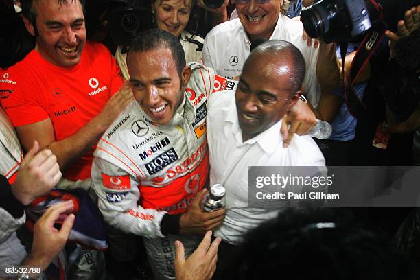 New Formula One World Champion Lewis Hamilton of Great Britain and McLaren Mercedes celebrates with his father Anthony Hamilton in his team garage...