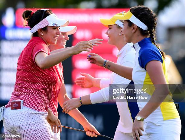 Gerina Piller and Stacy Lewis of Team USA receive a hug from Georgia Hall and Charley Hull of Team Europe after beating them two and one on the 17th...