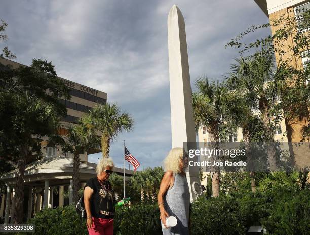 People walk past a granite obelisk commemorating Confederate Generals Stonewall Jackson, Robert E. Lee and Jefferson Davis and the memory of the...