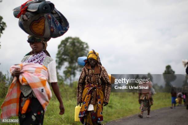 Congolese carry their belongings as they leave an Internally Displaced People camp in Kibati on November 2, 2008 outside of Goma, in the Democratic...