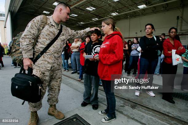 Cpl. Craig Blankenship says goodbye to his kids Carli and Curtis during a deployment ceremony for Marines from the Light Attack Helicopter Squadron...