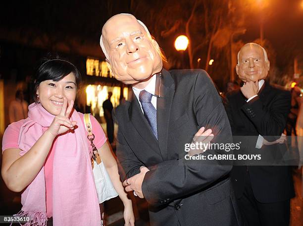 Men wearing masks of Republican US presidential candidate John McCain pose with a Japanses tourist at the West Hollywood Halloween costume carnival,...