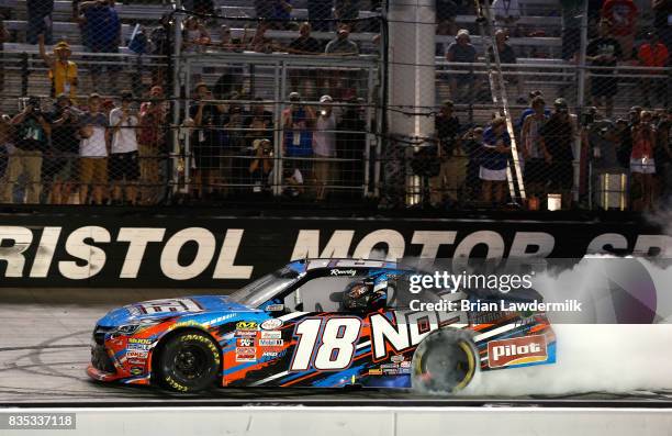 Kyle Busch, driver of the NOS Rowdy Toyota, celebrates with a burnout after winning the NASCAR XFINITY Series Food City 300 at Bristol Motor Speedway...