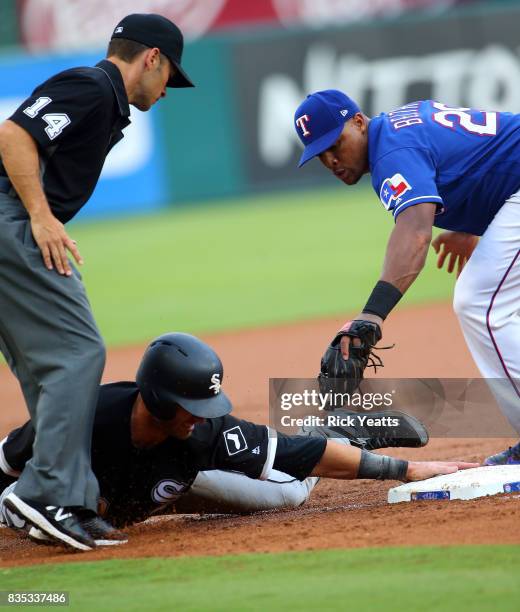 Umpire Mark Wegner looks on as Nicky Delmonico of the Chicago White Sox slides in safe against Adrian Beltre of the Texas Rangers in the first inning...