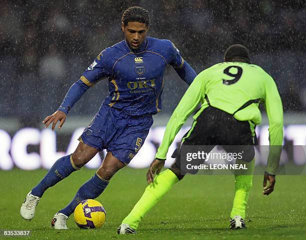 Portsmouth's Glen Johnson evades a tackle by Wigan's Emile Heskey during a Premiership match at Fratton Park in Portsmouth, on November 1, 2008....