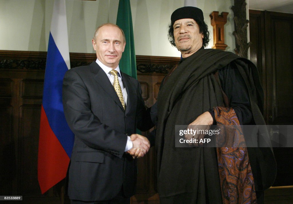 Libyan leader Moamer Kadhafi (R) shakes