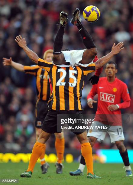 Manchester United's French defender Patrice Evra falls over Hull City's French-Gabonese forward Daniel Cousin during their English Premier league...
