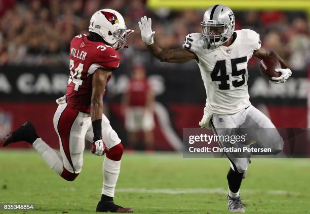 Running back George Atkinson of the Oakland Raiders runs with the football after a reception past free safety Harlan Miller of the Arizona Cardinals...