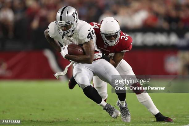 Running back George Atkinson of the Oakland Raiders runs with the football after a reception past free safety Harlan Miller of the Arizona Cardinals...