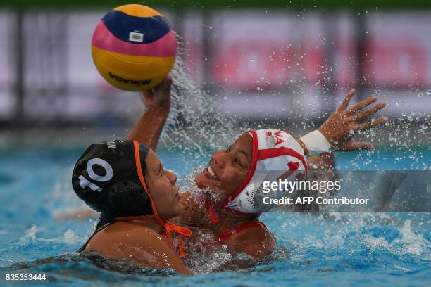 Indonesia's Rani Raida is challenged for the ball by Malaysia's Trisha Then Chiah Huey during their women's water polo round match at the 29th...