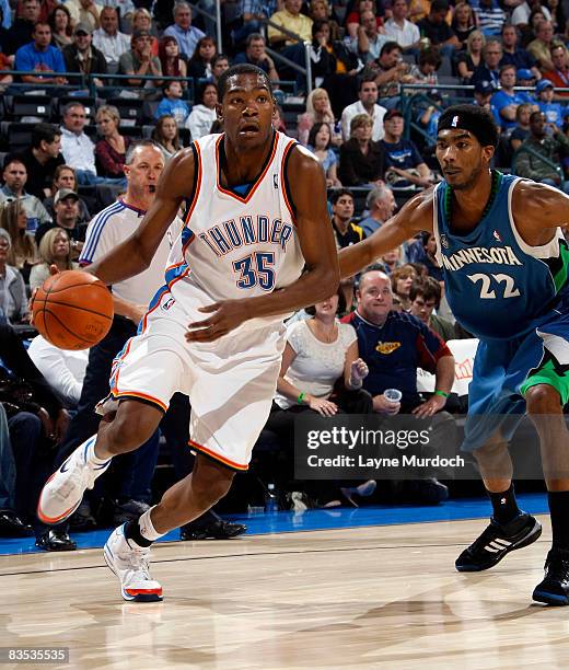 Kevin Durant of the Oklahoma City Thunder dribbles toward the basketball goal while being guarded by Corey Brewer of the Minnesota Timberwolves on...