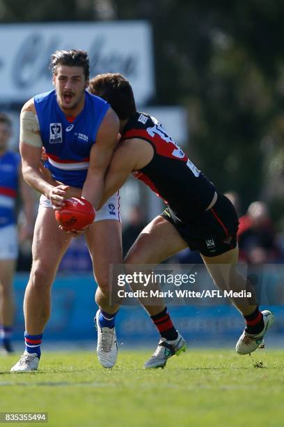 Tom Boyd of Footscray Bulldogs gets tackled by Kyle Langford of Essendon Bombers during the round 18 VFL match between the Essendon Bombers and...