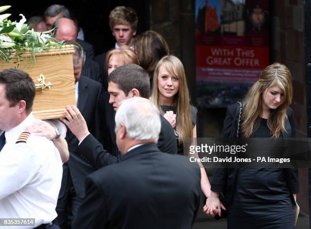 The coffin of helicopter co-pilot Richard Menzies, followed by his girlfriend Katherine Botham and sister Laura Menzies , is carried from his funeral...