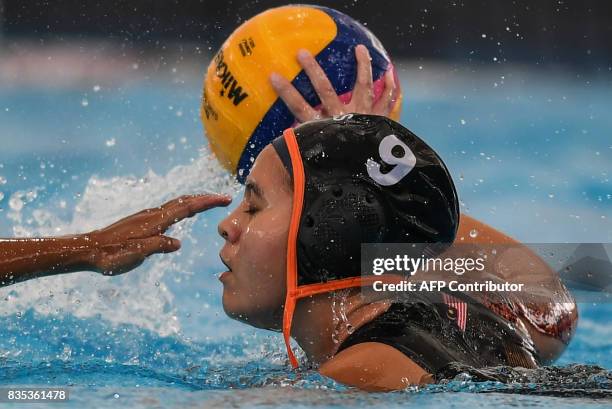 Malaysia's Izyan Syaza Abd Halim is challenged for the ball by Indonesia's Alya Nadira Trfiansyah during their women's water polo round match at the...