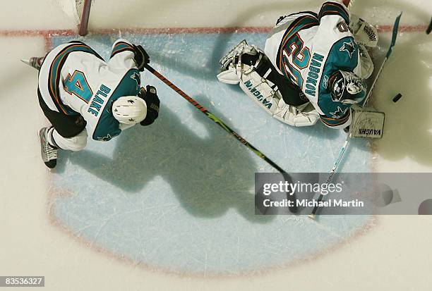 Goaltender Evgeni Nabokov of the San Jose Sharks makes a save as Rob Blake defends the crease against the Colorado Avalanche at the Pepsi Center on...