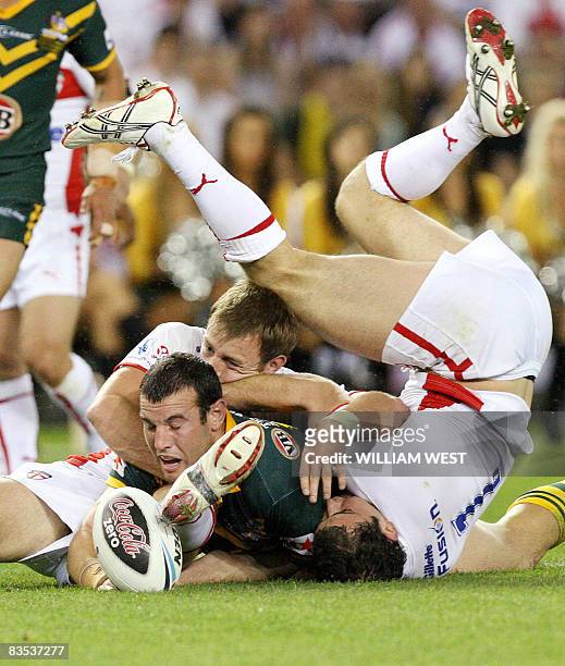 Australian player Gleen Stewart scores as England defenders Paul Wellens and James Roby in their Rugby League World Cup match at the Docklands...