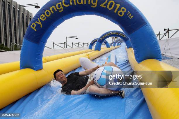 South Korean man slides down on a aeroplane shaped inflatable during the 'Bobsleigh In the City' on August 19, 2017 in Seoul, South Korea. The...