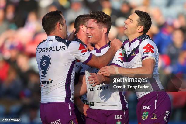 Brodie Croft of the Storm celebrates a try with team mates during the round 24 NRL match between the Newcastle Knights and the Melbourne Storm at...