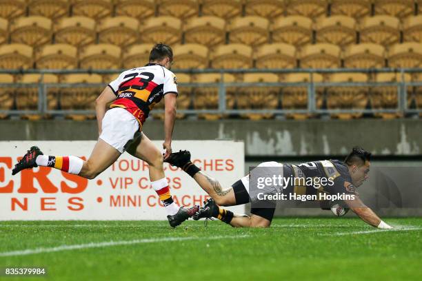 Beaudein Waaka of Taranaki crosses the line for a try while Tyler Campbell of Waikato looks on during the round one Mitre 10 Cup match between...