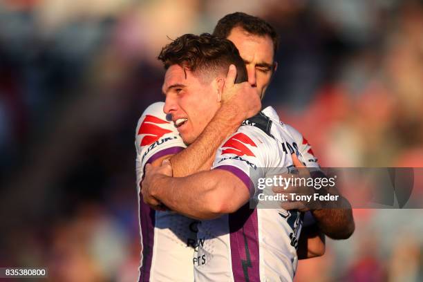 Brodie Croft of the Storm celebrates a try with team mate Cameron Smith during the round 24 NRL match between the Newcastle Knights and the Melbourne...