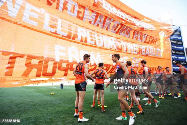Giants walk through their banner during the round 22 AFL match between the Greater Western Sydney Giants and the West Coast Eagles at Spotless...