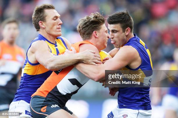 Lachie Whitfield of the Giants is challenged by Elliot Yeo of the Eagles and Drew Petrie of the Eagles during the round 22 AFL match between the...