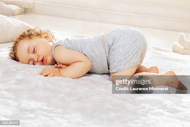 sleeping toddler lying on stomach bottom raised up - allongé sur le devant photos et images de collection