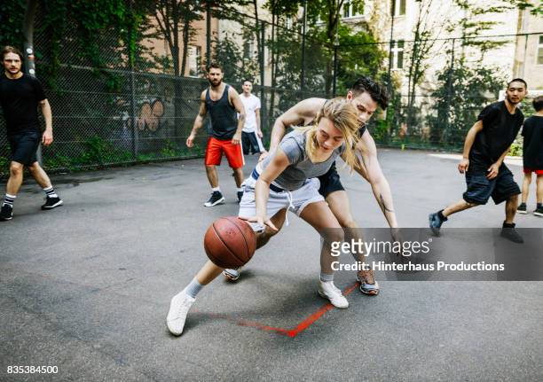 amateur athlete defending her position during basketball game - dribbling sport foto e immagini stock