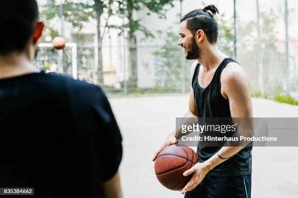 young man holding basketball ready to start the game - topknot stock pictures, royalty-free photos & images