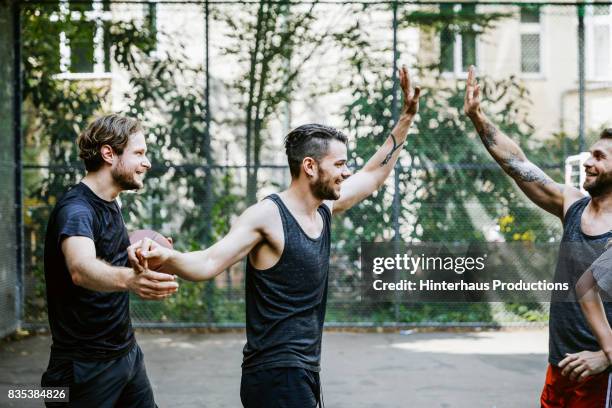 teammates high five, celebrating point score during basketball game - sports team high five stock pictures, royalty-free photos & images