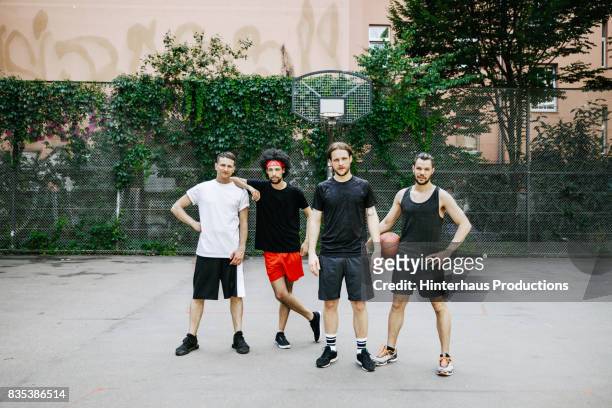 four basketball players together on their favourite court - four people stock-fotos und bilder
