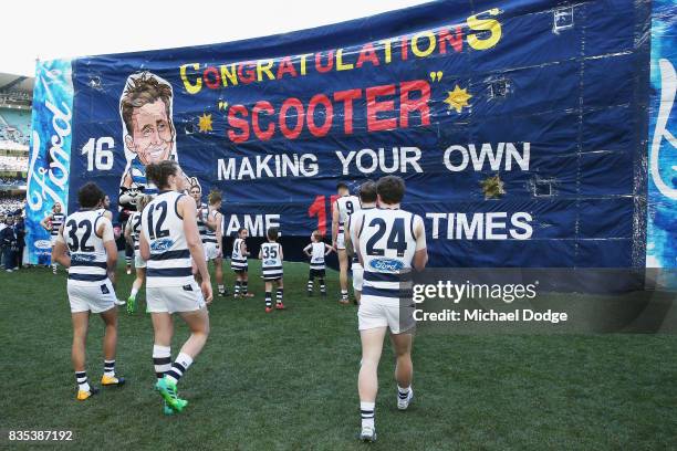 Cats players walk to their banner during the round 22 AFL match between the Collingwood Magpies and the Geelong Cats at Melbourne Cricket Ground on...