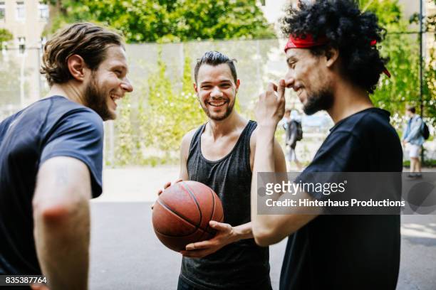 group of friends having fun together at an outdoor basketball court - basketball sport stock-fotos und bilder