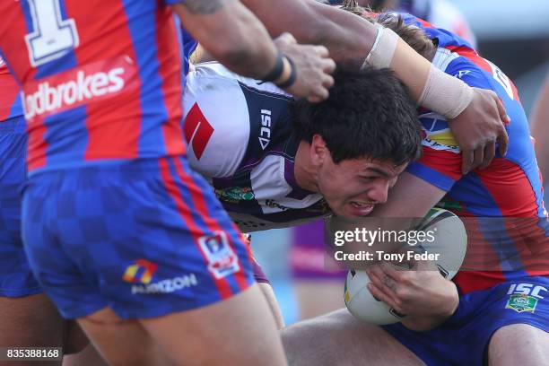 Jordan McLean of the Storm is tackled during the round 24 NRL match between the Newcastle Knights and the Melbourne Storm at McDonald Jones Stadium...