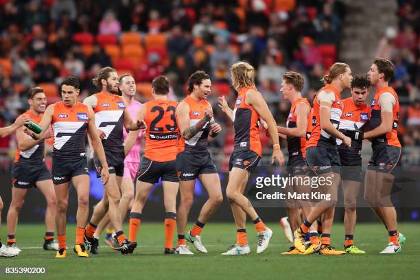 Nathan Wilson of the Giants celebrates with team mates after kicking a long range goal during the round 22 AFL match between the Greater Western...