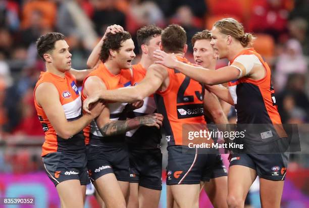 Nathan Wilson of the Giants celebrates with team mates after kicking a long range goal during the round 22 AFL match between the Greater Western...