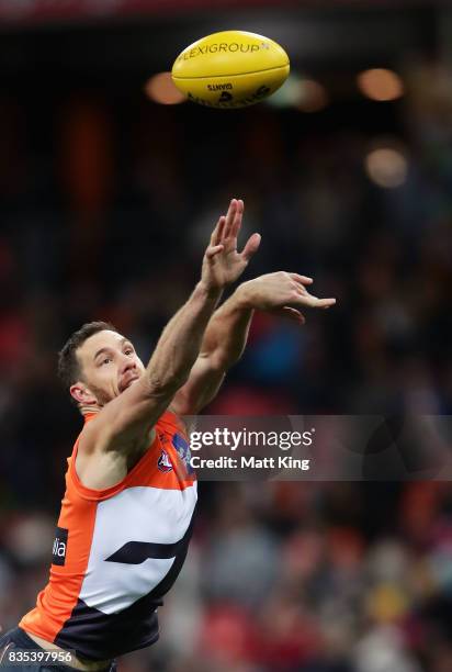 Shane Mumford of the Giants handles the ball during the round 22 AFL match between the Greater Western Sydney Giants and the West Coast Eagles at...