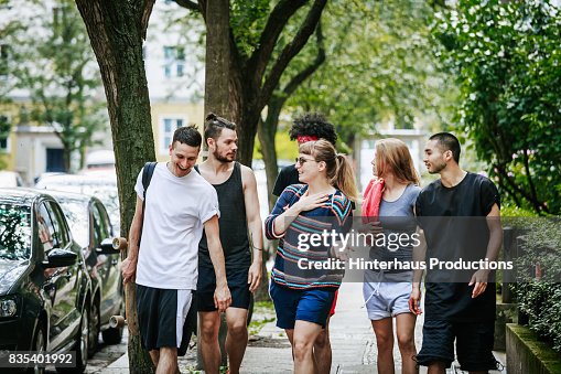 Group Of Friends Walking Home After Day Of Playing Sports Together Group Of Friends Walking Home After Day Of Playing Sports Together