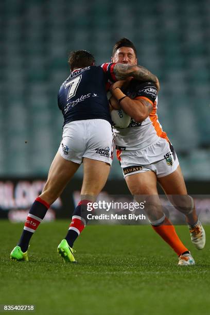 Malakai Watene-Zelezniak of the Tigers is tackled during the round 24 NRL match between the Sydney Roosters and the Wests Tigers at Allianz Stadium...