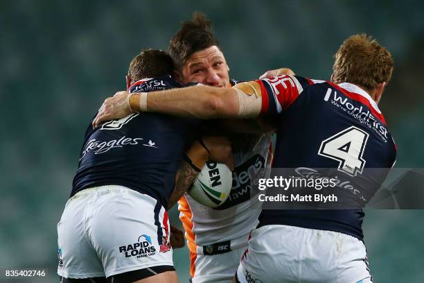 Malakai Watene-Zelezniak of the Tigers is tackled during the round 24 NRL match between the Sydney Roosters and the Wests Tigers at Allianz Stadium...