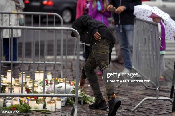 Man lays candles at the memorial for the victims of Friday's stabbings at the Turku Market Square, Finland on August 19, 2017. Two people were killed...